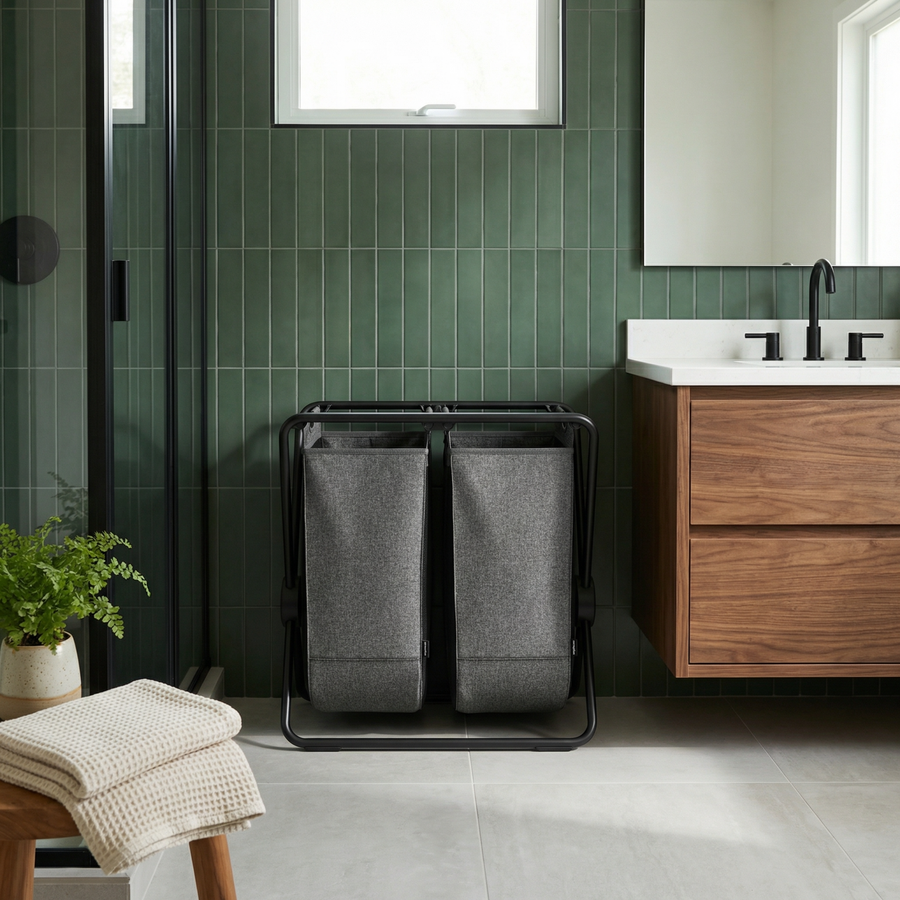 Simplehuman's Double X-Frame Hamper in a modern bathroom setting with green tiles.