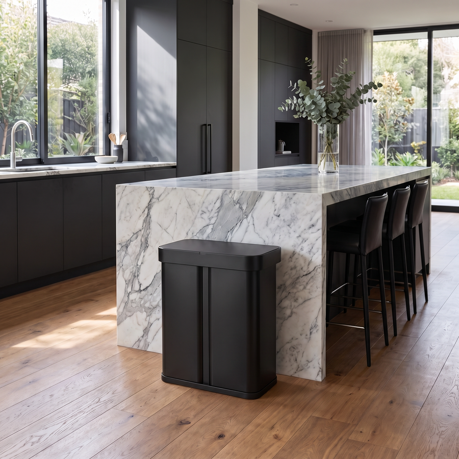 Simplehuman's Sensor Recycler in Matte Black in a modern kitchen setting with black cabinets and natural light. 